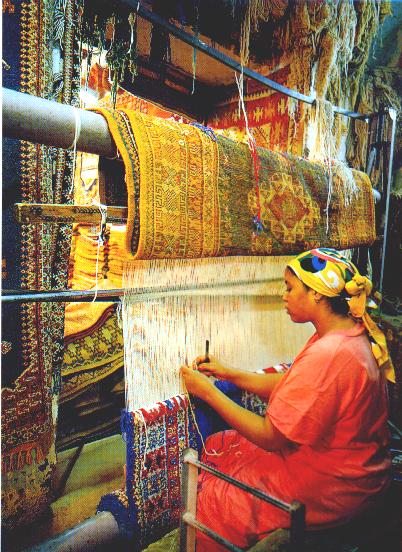 woman, traditionally weaving a carpet 